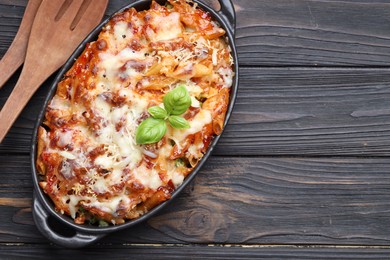 Photo of Delicious al forno pasta in baking dish on wooden table, top view. Space for text