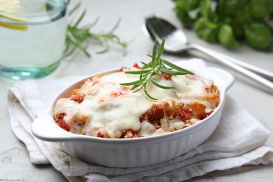 Photo of Delicious al forno pasta in baking dish on light table, closeup