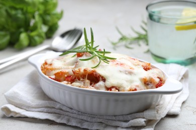 Photo of Delicious al forno pasta in baking dish on light table, closeup