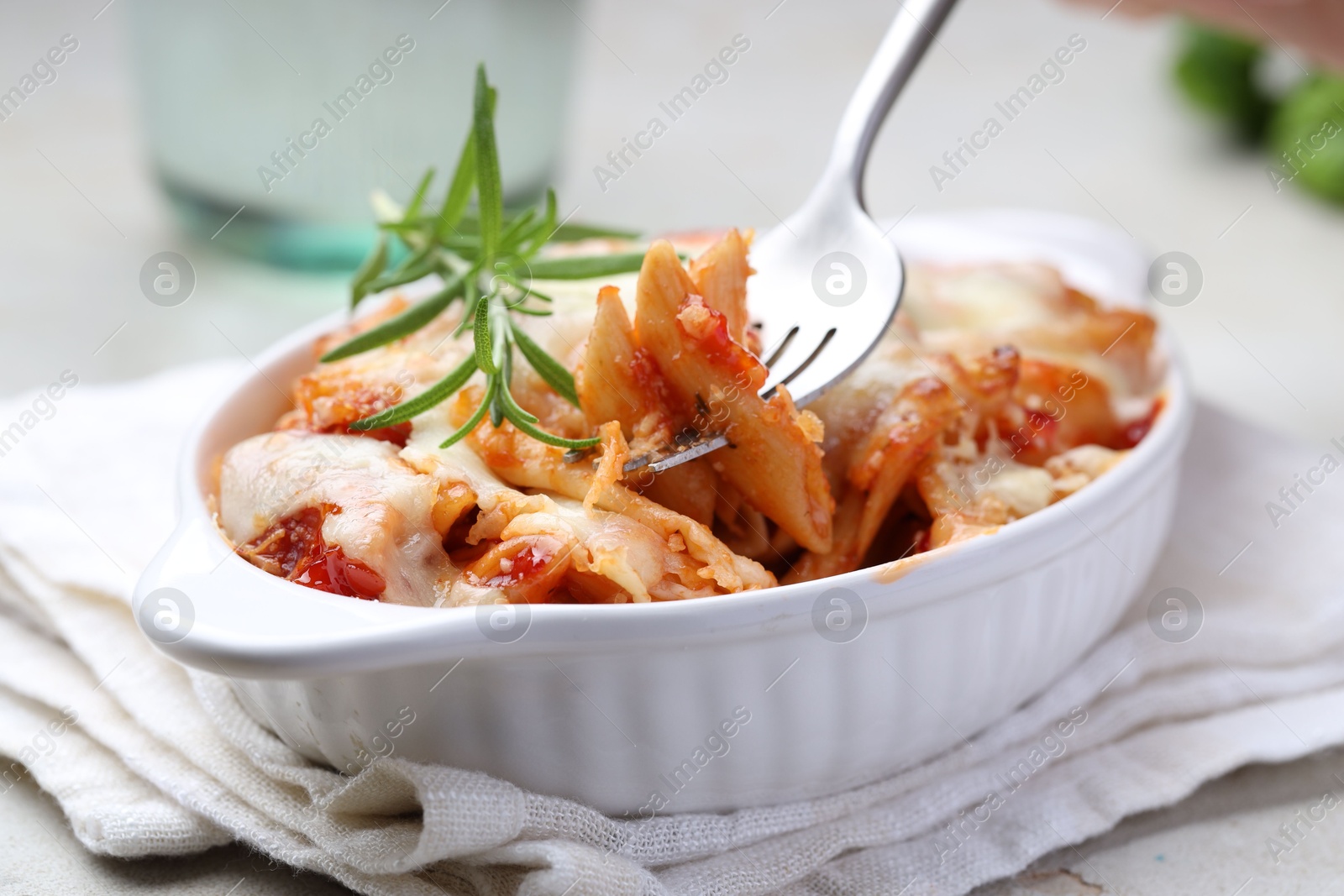 Photo of Eating delicious al forno pasta at light table, closeup