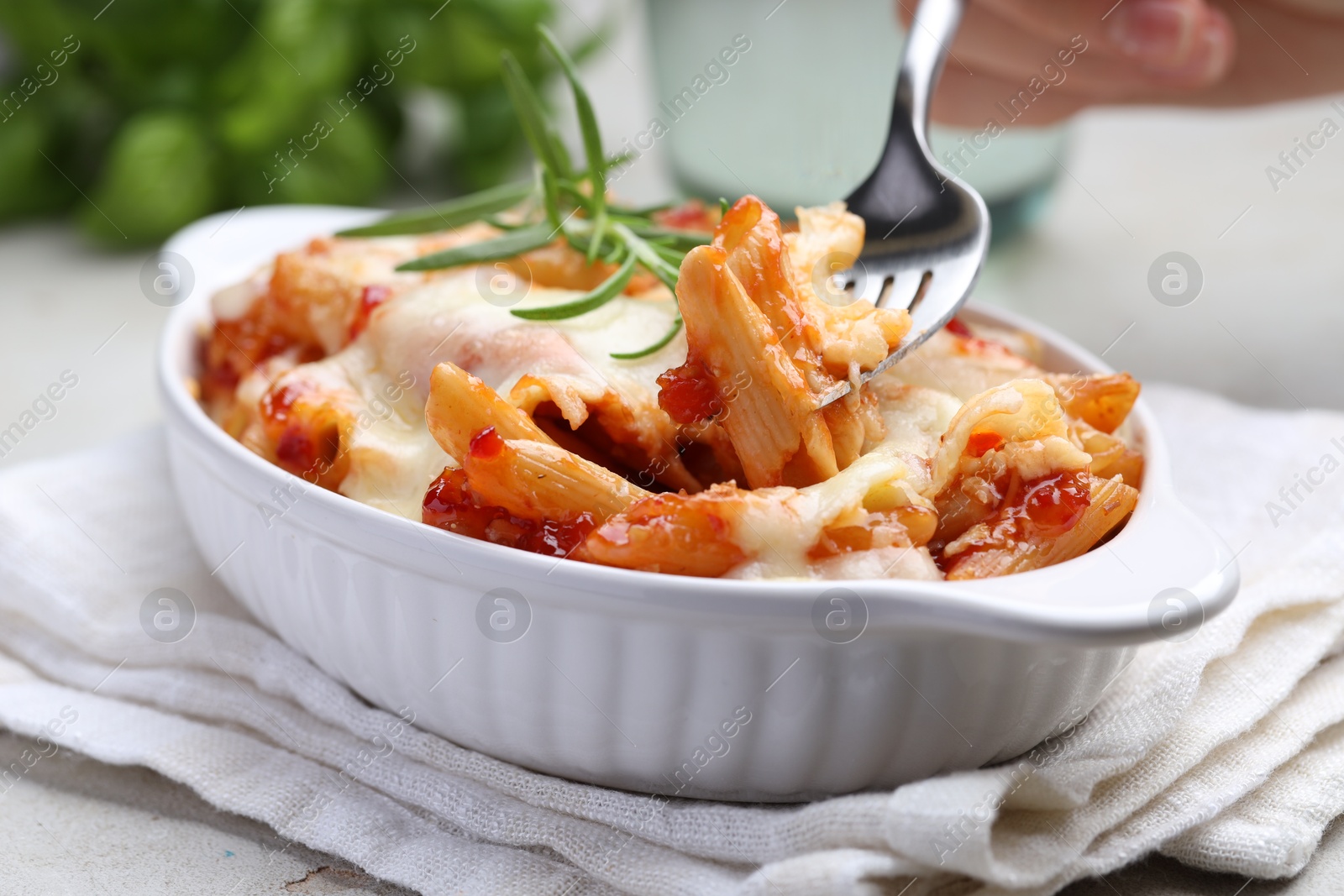 Photo of Eating delicious al forno pasta at light table, closeup