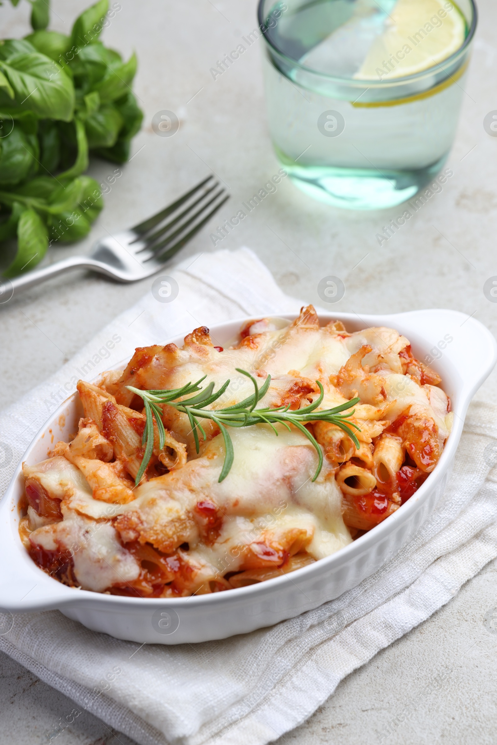 Photo of Delicious al forno pasta in baking dish on light table