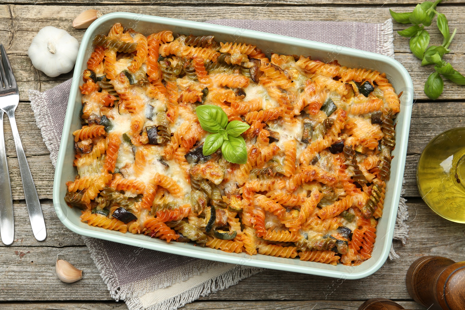 Photo of Delicious al forno pasta in baking dish on wooden table, flat lay