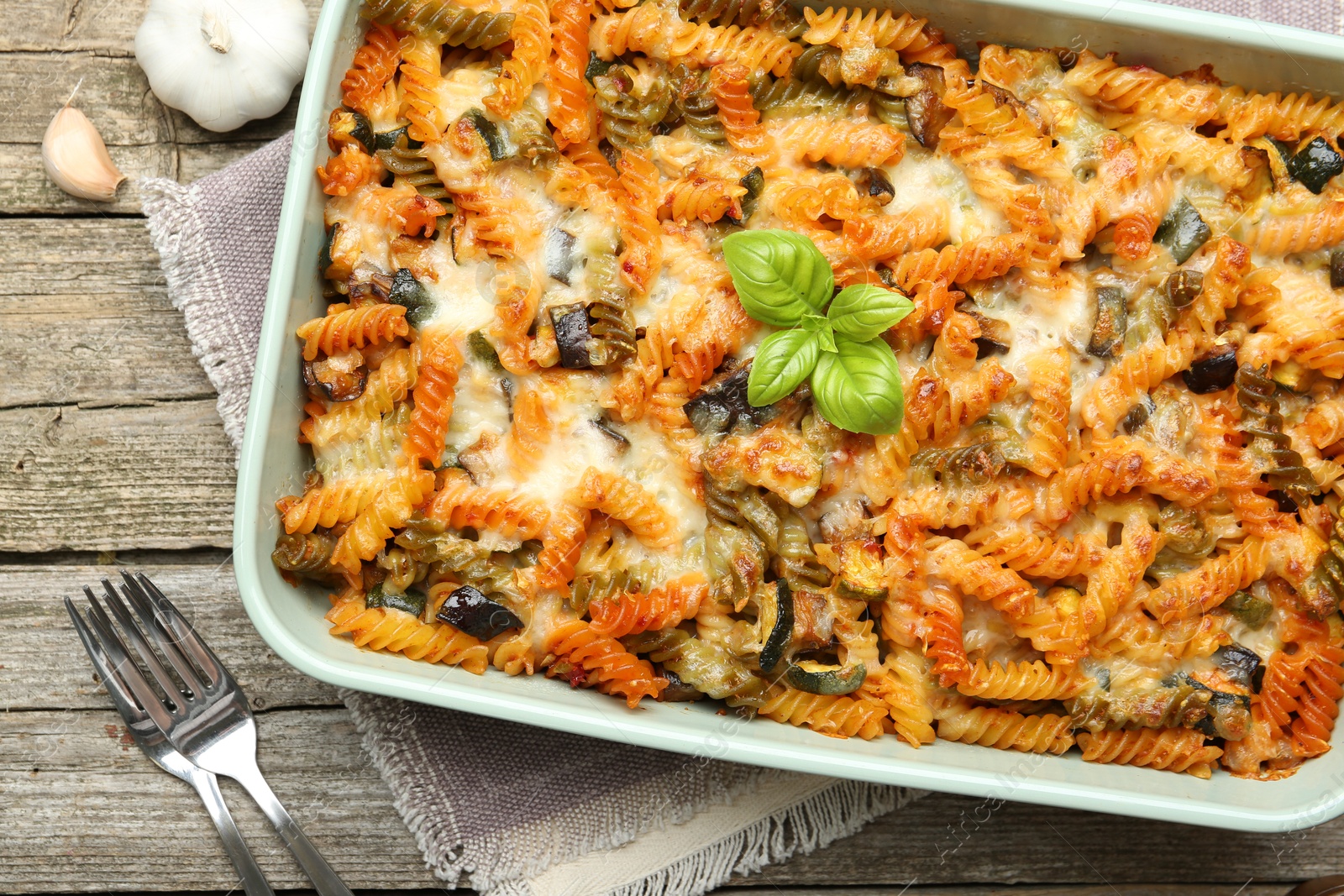 Photo of Delicious al forno pasta in baking dish on wooden table, top view