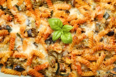 Photo of Delicious al forno pasta with basil, closeup