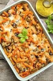 Photo of Delicious al forno pasta in baking dish on wooden table, top view