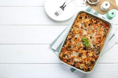 Photo of Delicious al forno pasta in baking dish on white wooden table, flat lay. Space for text