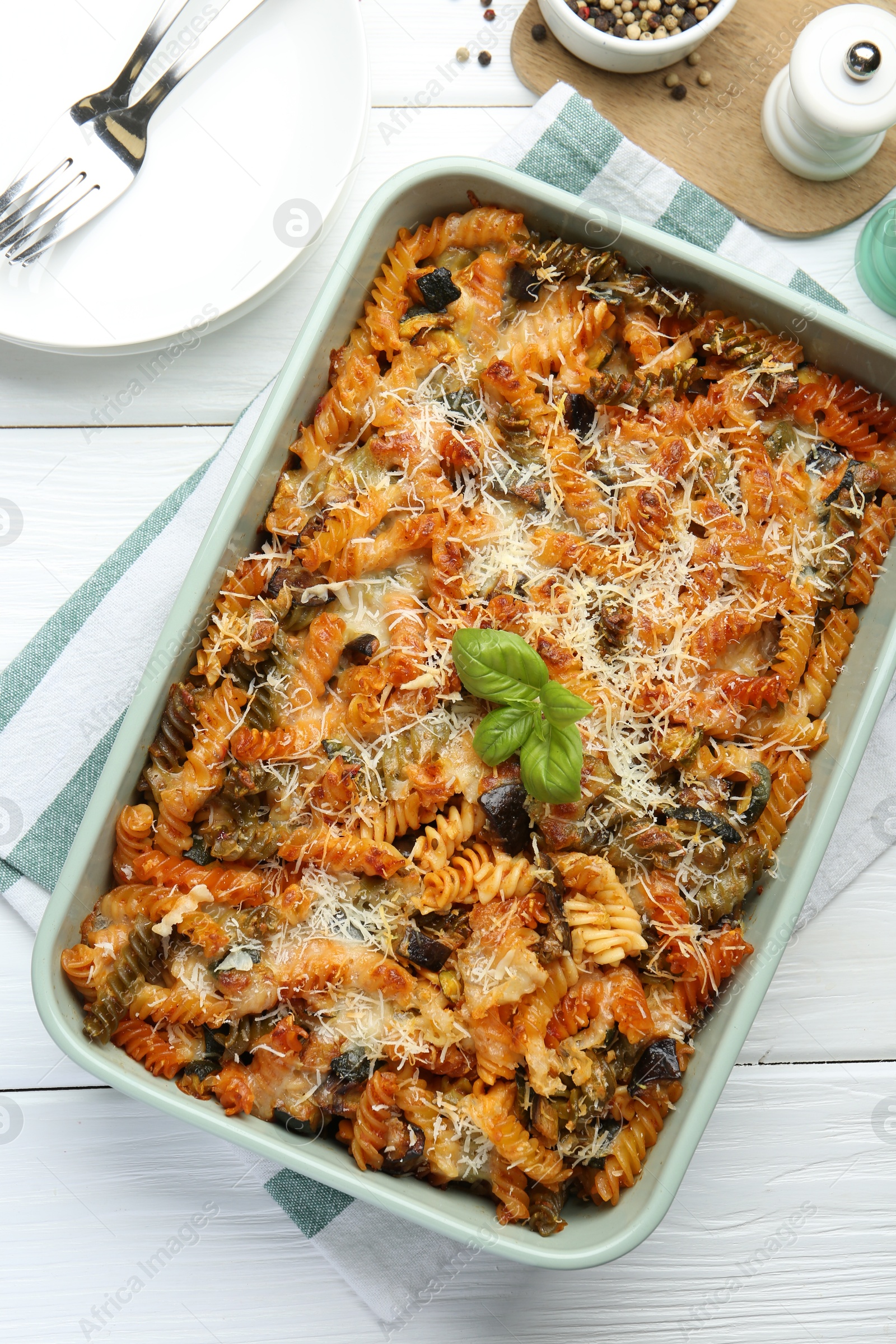 Photo of Delicious al forno pasta in baking dish on white wooden table, flat lay