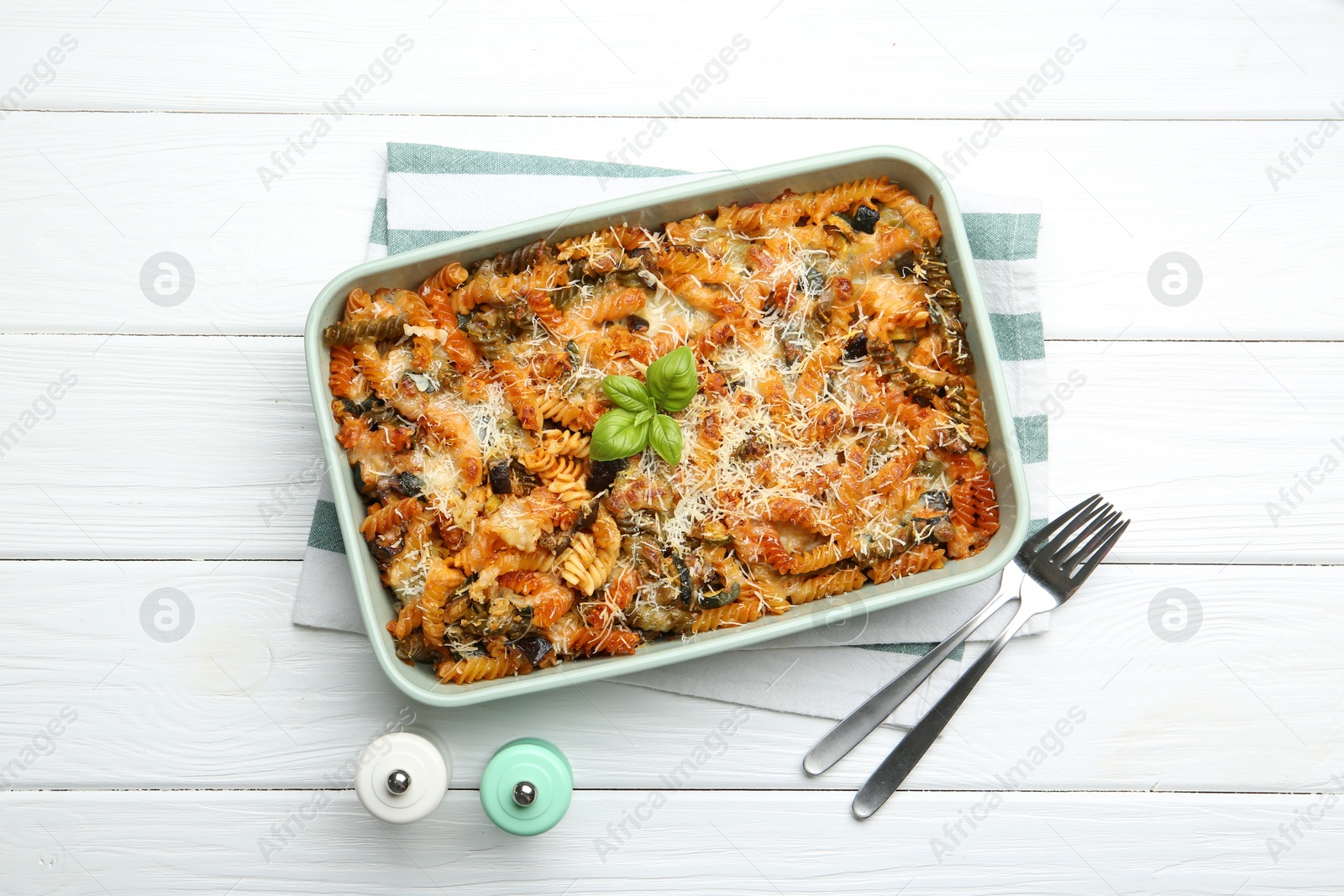 Photo of Delicious al forno pasta in baking dish on white wooden table, flat lay