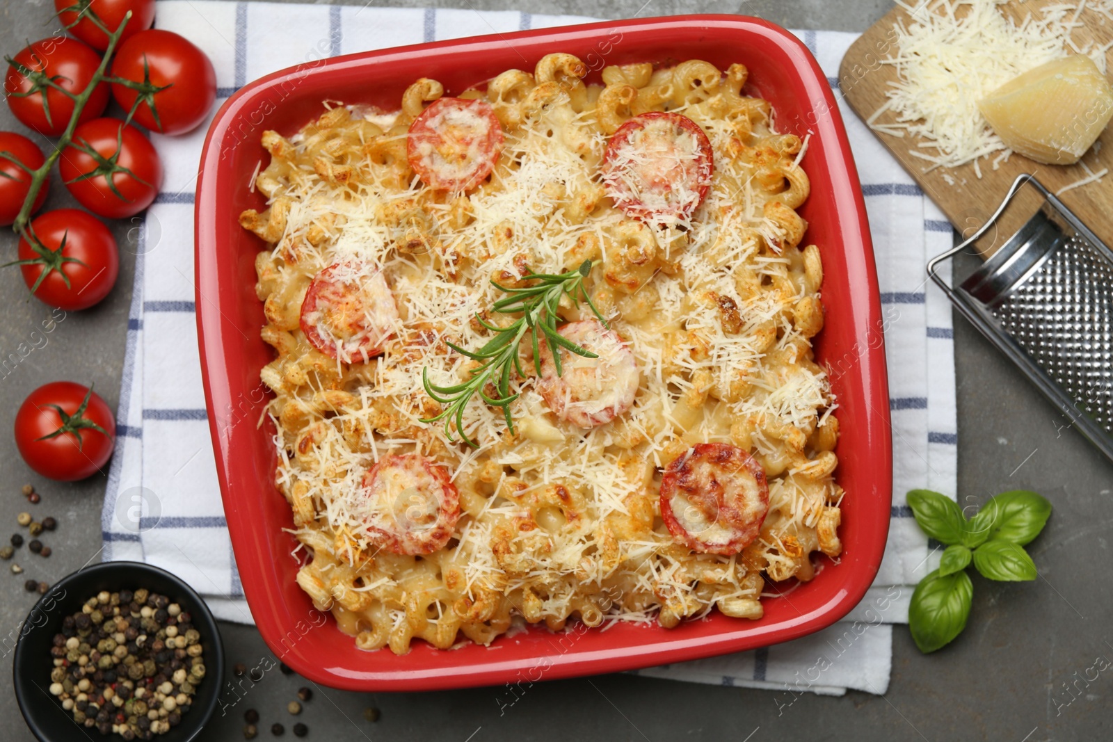 Photo of Delicious al forno pasta in baking dish on grey table, flat lay