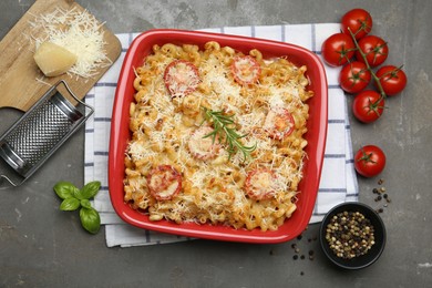 Photo of Delicious al forno pasta in baking dish on grey table, flat lay