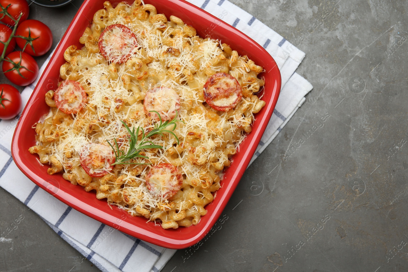 Photo of Delicious al forno pasta in baking dish on grey table, flat lay