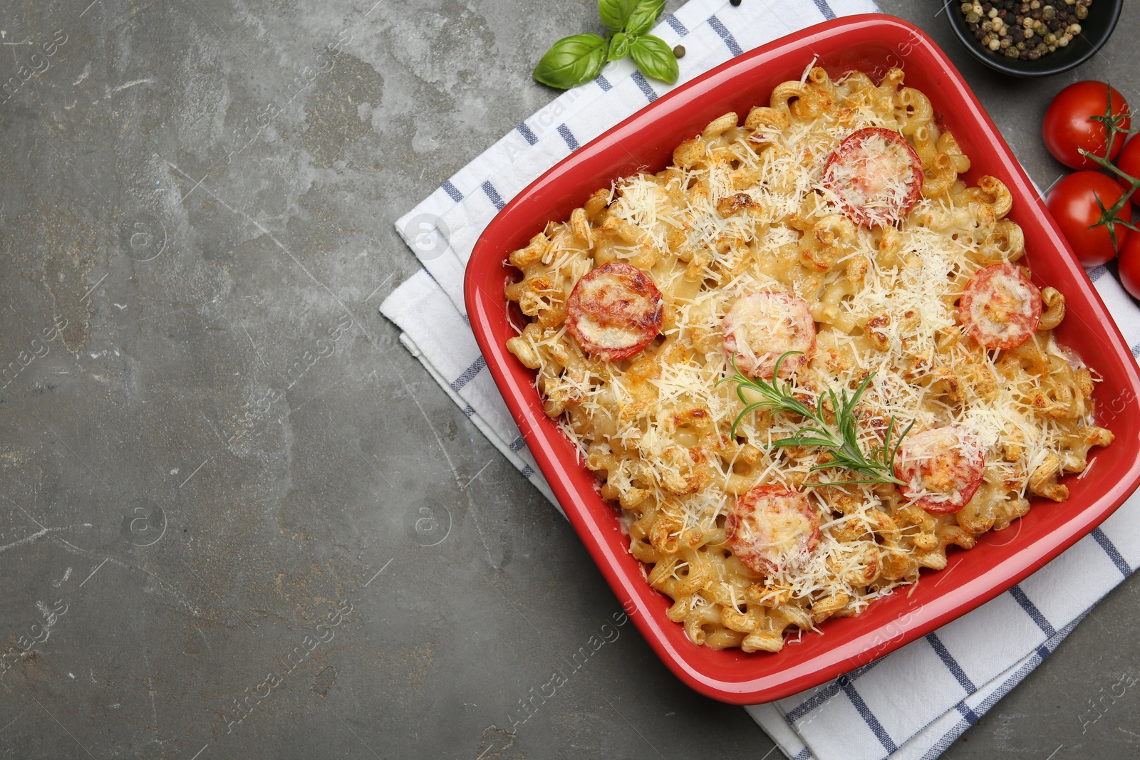 Photo of Delicious al forno pasta in baking dish on grey table, flat lay. Space for text