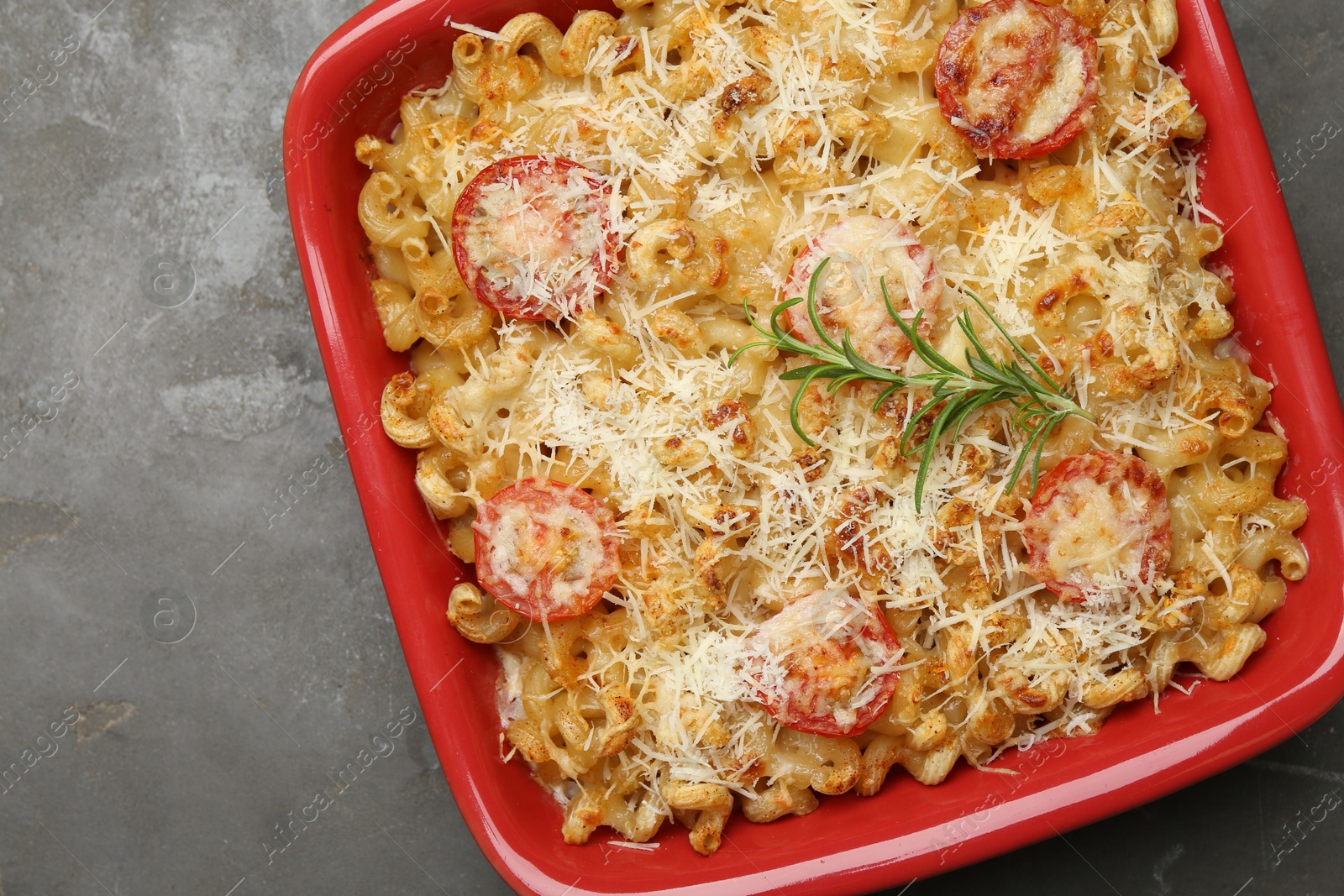 Photo of Delicious al forno pasta in baking dish on grey table, top view