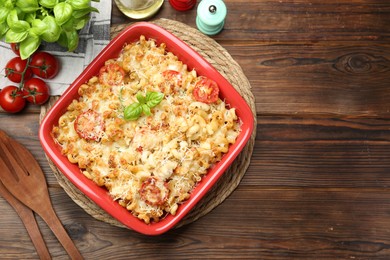 Photo of Delicious al forno pasta in baking dish on wooden table, flat lay