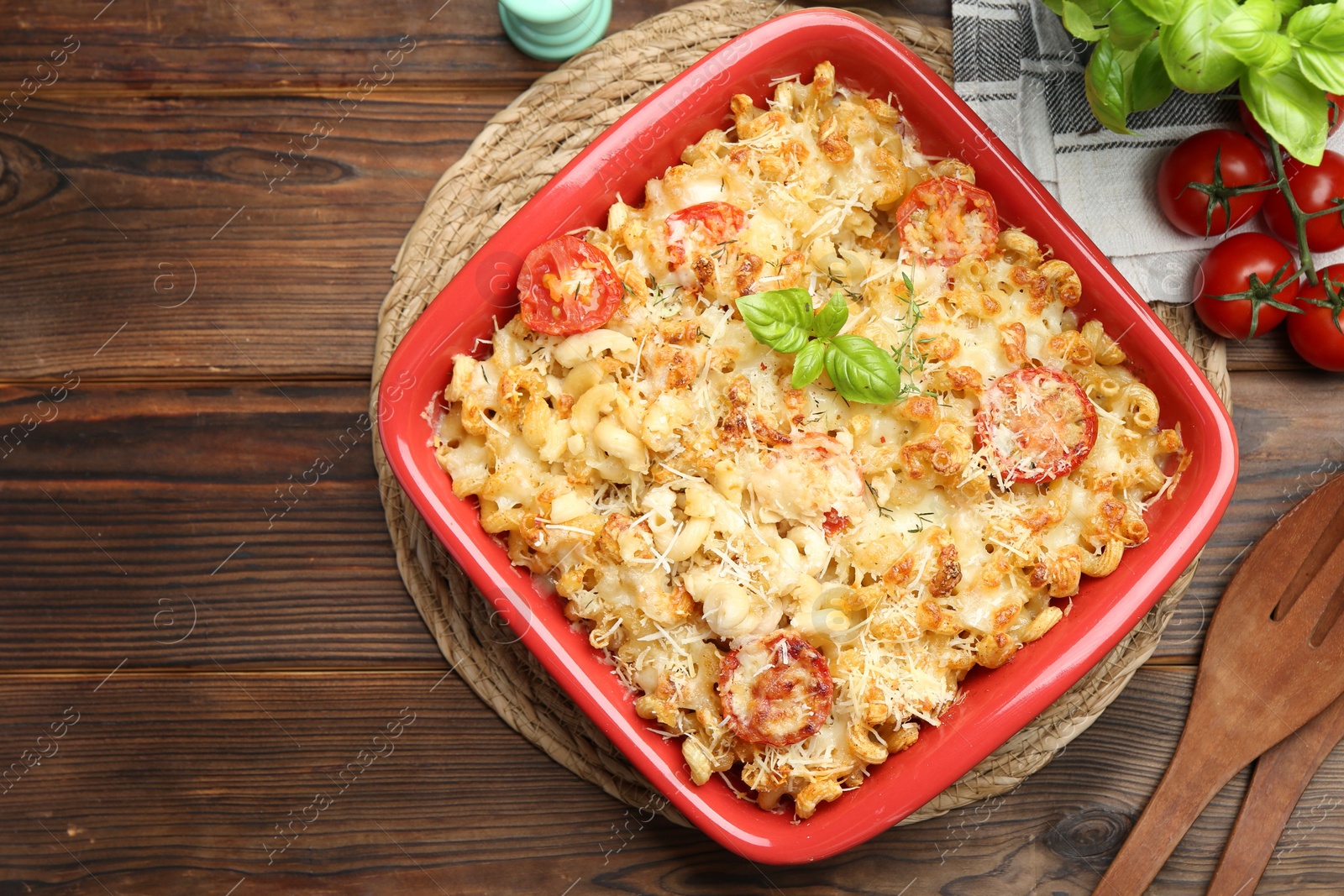 Photo of Delicious al forno pasta in baking dish on wooden table, flat lay