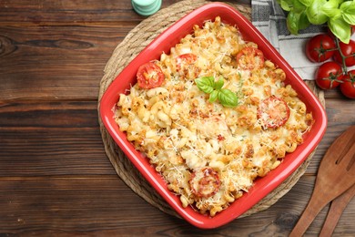 Photo of Delicious al forno pasta in baking dish on wooden table, flat lay