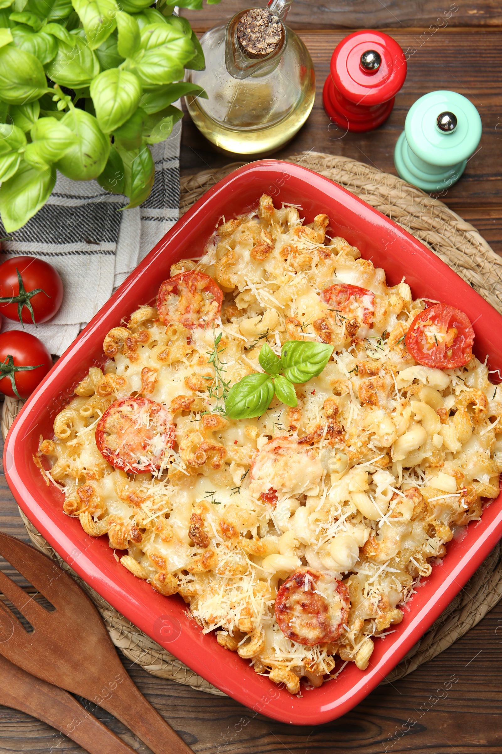 Photo of Delicious al forno pasta in baking dish on wooden table, flat lay