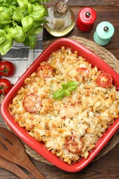 Photo of Delicious al forno pasta in baking dish on wooden table, flat lay