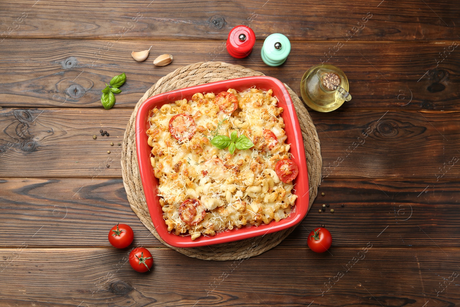 Photo of Delicious al forno pasta in baking dish on wooden table, flat lay