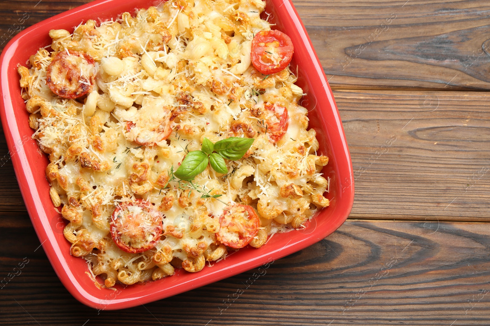 Photo of Delicious al forno pasta in baking dish on wooden table, top view