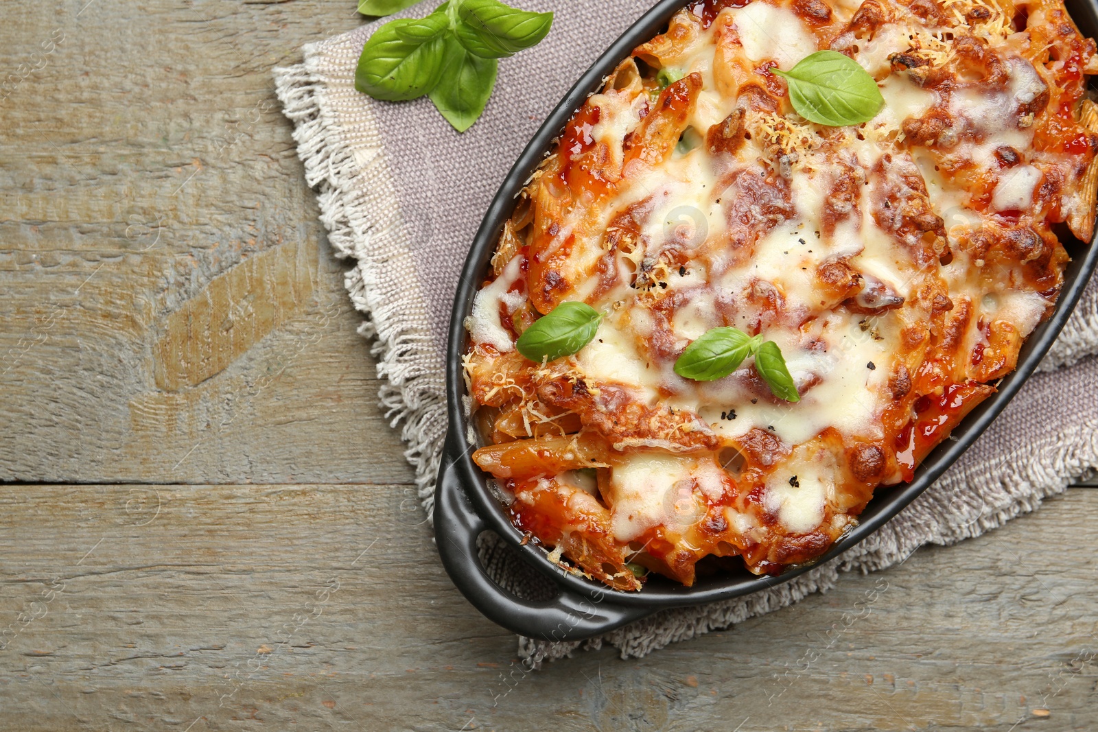 Photo of Delicious al forno pasta in baking dish on wooden table, top view