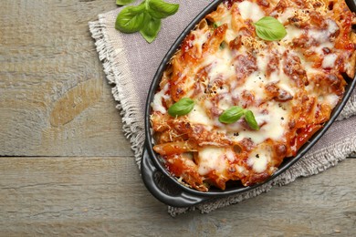 Photo of Delicious al forno pasta in baking dish on wooden table, top view