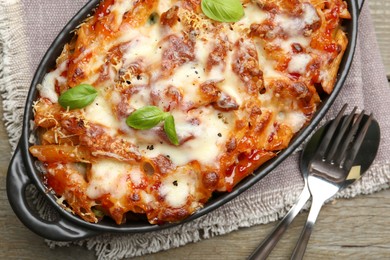 Photo of Delicious al forno pasta in baking dish on wooden table, top view