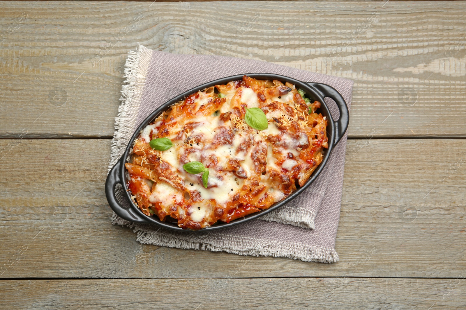 Photo of Delicious al forno pasta in baking dish on wooden table, top view