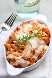 Photo of Delicious al forno pasta in baking dish on light table, closeup