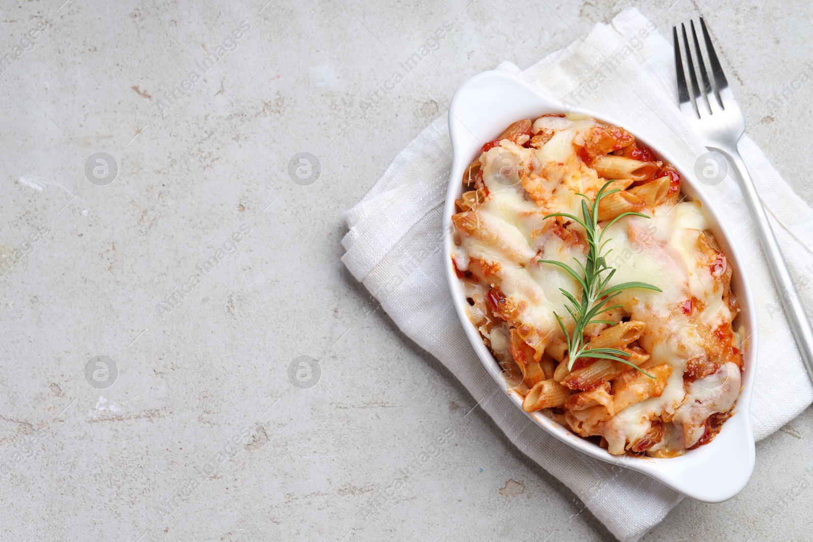 Photo of Delicious al forno pasta in baking dish on light table, top view. Space for text