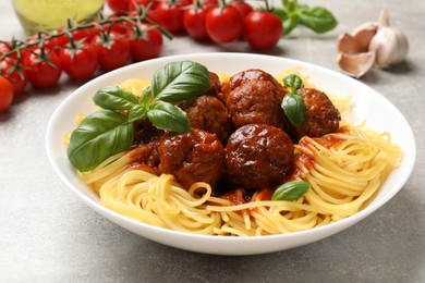 Delicious pasta with meatballs and ingredients on grey table, closeup