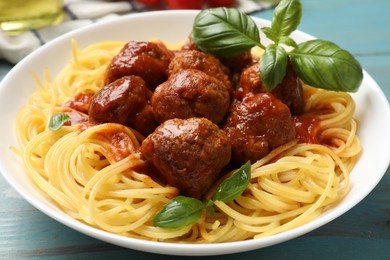 Photo of Delicious pasta with meatballs on blue wooden table, closeup