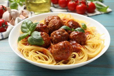 Photo of Delicious pasta with meatballs and ingredients on blue wooden table, closeup