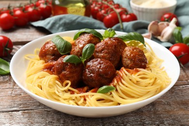 Delicious pasta with meatballs and ingredients on wooden table, closeup