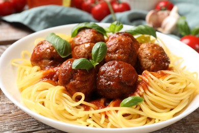 Delicious pasta with meatballs and ingredients on wooden table, closeup