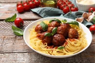 Delicious pasta with meatballs and ingredients on wooden table, closeup