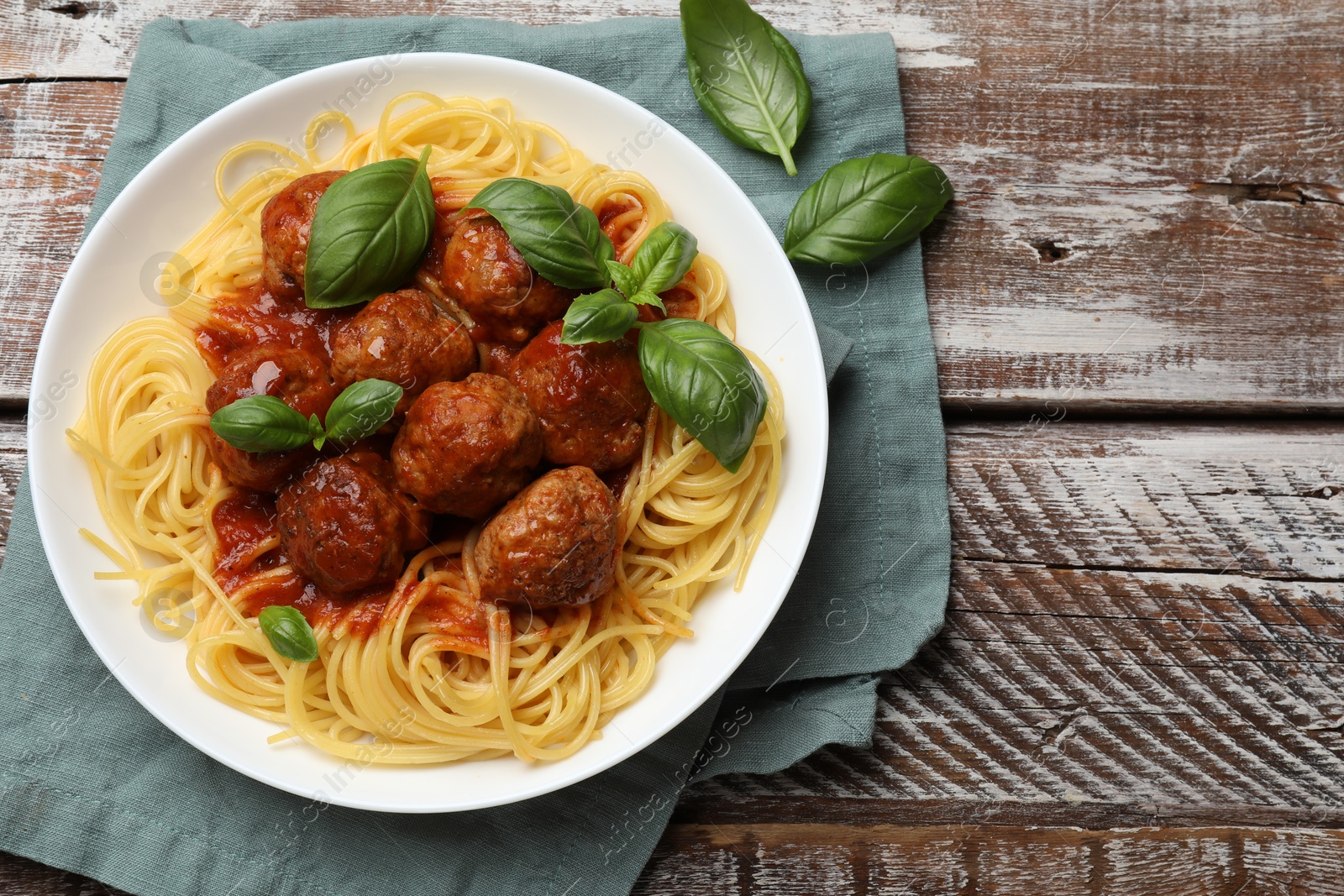 Photo of Delicious pasta with meatballs on wooden table, top view