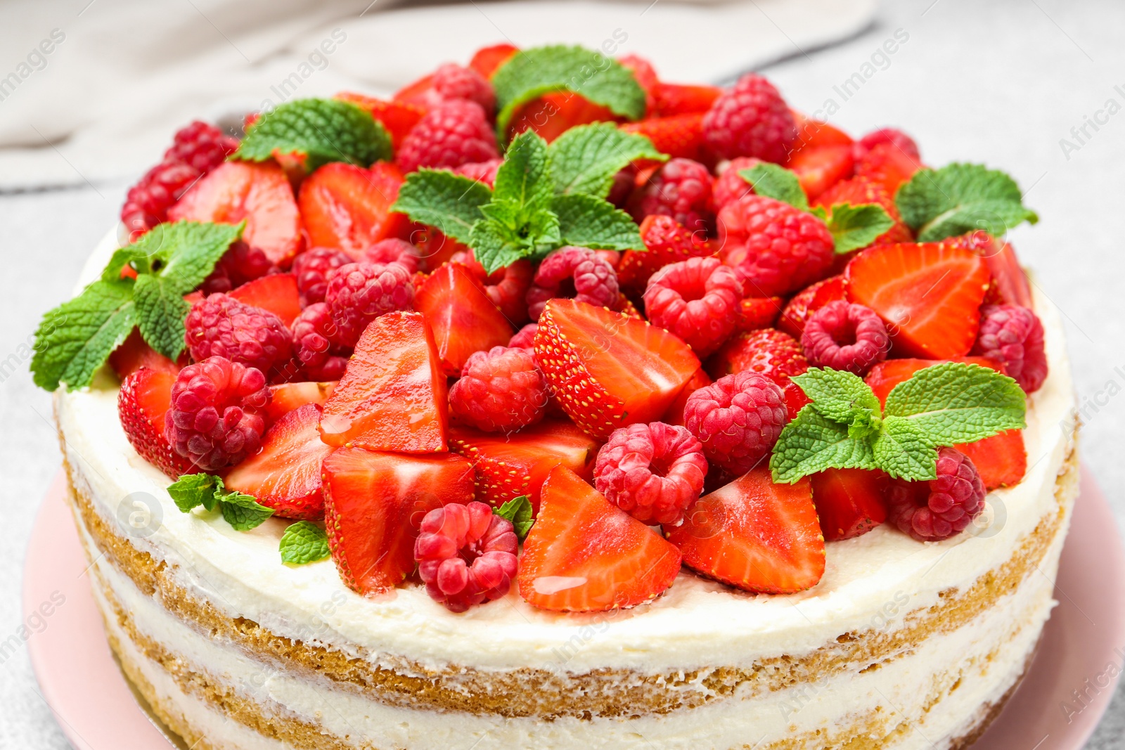 Photo of Tasty sponge cake with fresh berries and mint on table, closeup