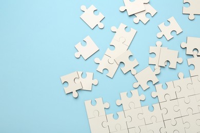 Photo of White puzzle pieces on light blue background, top view