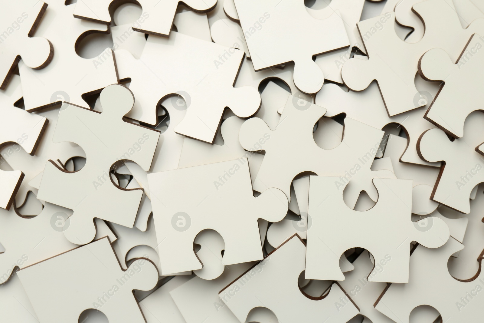 Photo of Pile of white puzzle pieces as background, top view