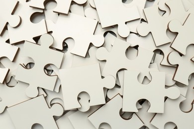 Pile of white puzzle pieces as background, top view