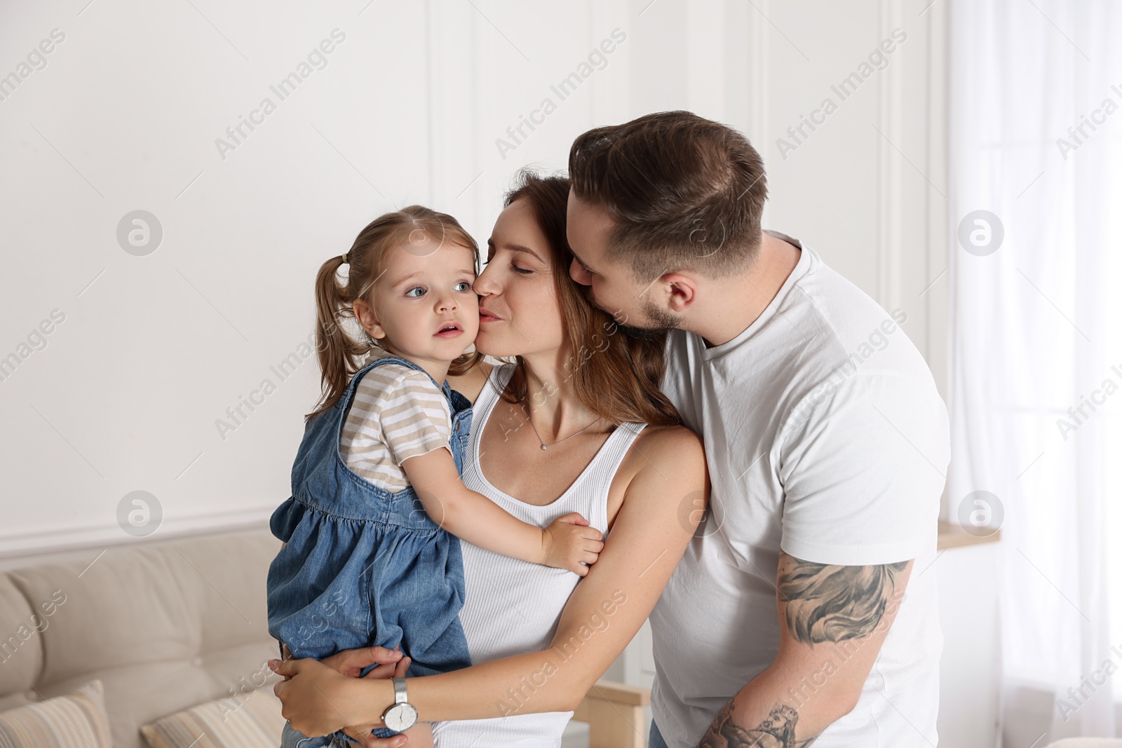 Photo of Happy family. Parents and their cute little daughter at home