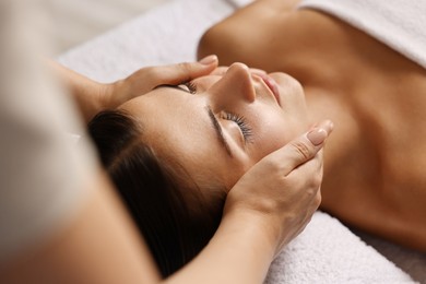 Attractive woman enjoying face massage, closeup. Beauty procedure