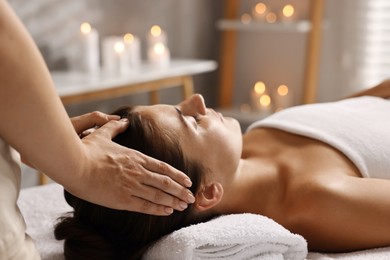 Photo of Attractive woman enjoying face massage in spa salon, closeup