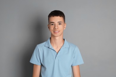 Photo of Portrait of teenage boy on grey background