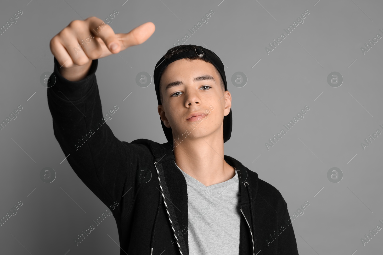 Photo of Portrait of teenage boy on grey background