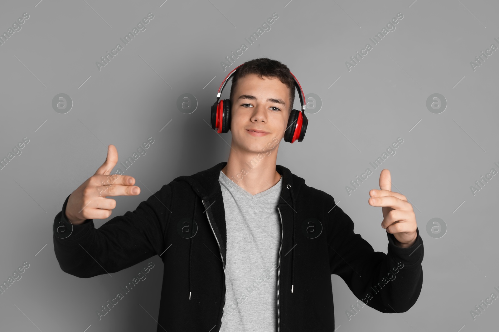 Photo of Portrait of teenage boy with headphones on grey background