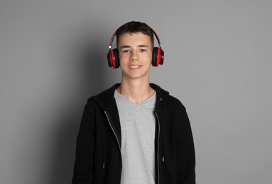 Photo of Portrait of teenage boy with headphones on grey background