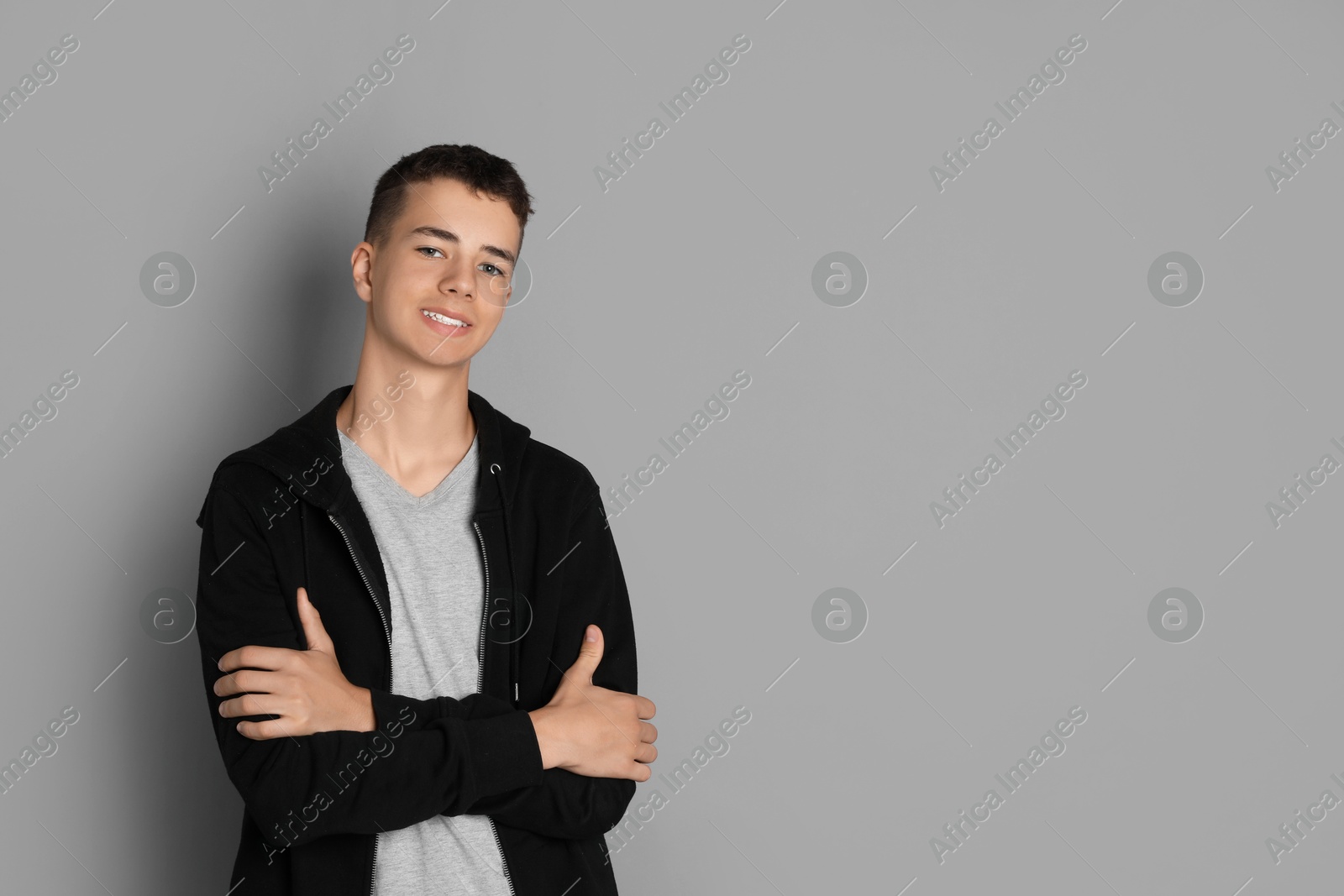 Photo of Portrait of teenage boy on grey background, space for text